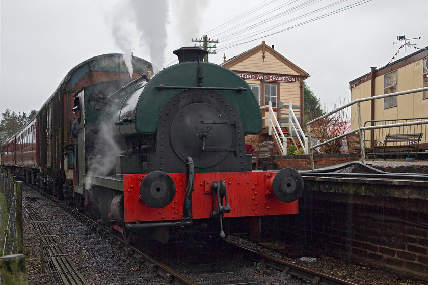 2104, 13.00 Pitsford & Brampton return, Pitsford & Brampton station 
 Northampton and Lamport Railway's Peckett 0-4-0 2104 blows off at Pitsford and Brampton station. It was waiting to depart with 13.00 Mince Pie Special return working. Notice in the background, the signal box. This controls the signalling and points within the station area. The box was originally situated at Little Bowden Crossing in Market Harborough. This 1879 LNWR signal box shut when the Market Harborough to Northampton line, on which the NLR is situated, closed in 1981. 
 Keywords: 2104 Pitsford & Brampton station Northampton and Lamport Railway