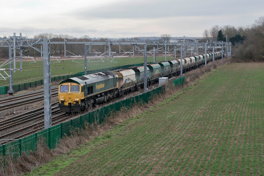 66531, 15.52 Radlett Redland-East Usk Yard (6V54, 21E), Harrowden Junction 
 66731 is seen leading tatty looking and graffiti ravaged former coal wagons now converted to carry stone and ballast past Wellingborough's Harrowden Junction. The 15.52 Radlett to East Usk Yard 6V54 (thanks to Mike for the reporting number) is commonly known in this area by enthusiasts as the Redlands and is a pretty dependable working. As can be seen here it is on the down fast where it will stay until it curves away from the slow lines at Kettering North Junction. I suspect that if a full timetable was in operation rather than the COVID induced seventy-five per cent version that this train would have progressed along the slow line from its start point at Radlett as far as here, the last place that it could move to the fast before the lines split. 
 Keywords: 66531 15.52 Radlett Redland-East Usk Yard 6V54 Harrowden Junction Freightliner