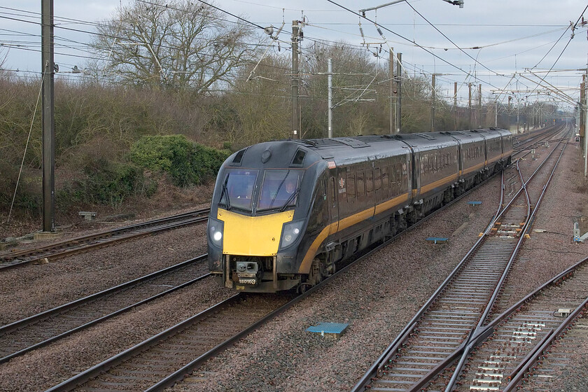 180103, GC 06.55 Bradford Exchange-London King's Cross (1A59, 1L), Tallington 
 I like Tallington on the ECML a few miles north of Peterborough as the railway photographer gets plenty of warning of the passage of a train and it offers a variety of views of the line. Taken through the footbridge that permits pedestrians to cross the line when the level crossing barriers are lowered 180103 is seen working the 06.55 Bradford Exchange to King's Cross Grand Central service. As is usual with these units it could be heard in the distance well before it was actually in view and was identifiable! 
 Keywords: 180103 06.55 Bradford Exchange-London King's Cross 1A59 Tallington Grand Central