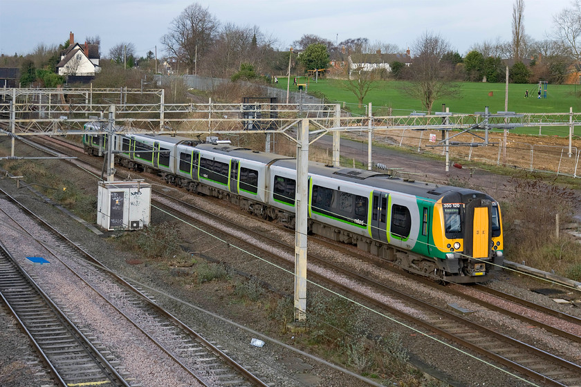 350120, LM 11.14 Birmingham New Street-London Euston (1Y34), site of Roade station 
 350120 passes the site of Roade's former station working the 11.14 Birmingham New Street to Euston service. Unfortunately, the building work in the background with the fenced-off land is not part of a grand reopening plan for the station but the first stages of the clearance of the former Pianoforte factory for yet more housing that makes the case for reopening an even more compelling proposition! 
 Keywords: 350120 11.14 Birmingham New Street-London Euston 1Y34 site of Roade station London Midland Desiro