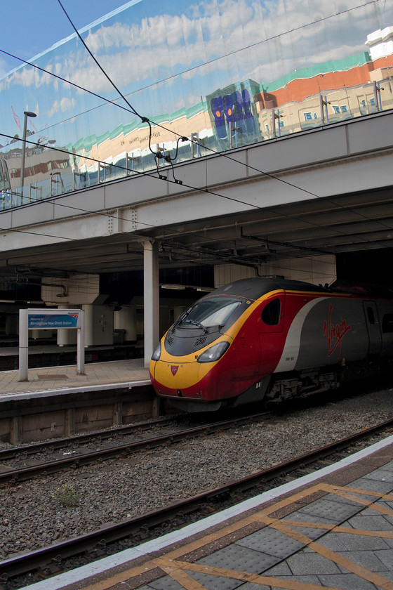 390152, VT 12.52 Edinburgh-London Euston (9M56, 6L), Birmingham New Street station 
 The huge new structure that sits above the platforms of Birmingham New Street station contains the vast station concourse and then above that an equally vast area of retailing and eateries. The exterior of the building is clad in these somewhat controversial stainless steel panels that have been 'dulled down' in an effort to avoid refective problems. VT's 390152 'Virgin Spirit' pauses at the station with the 12.52 Edinburgh to Euston. 
 Keywords: 390152 12.52 Edinburgh-London Euston 9M56 Birmingham New Street station