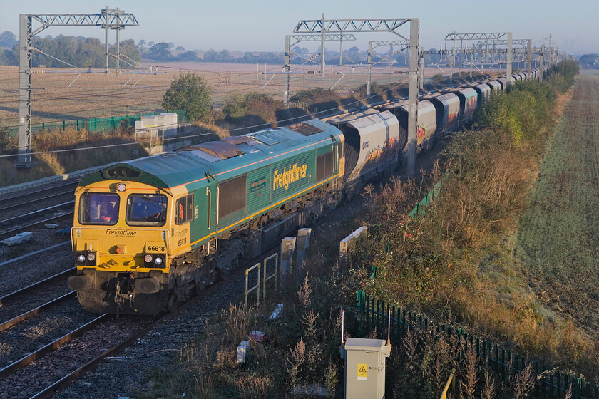 66618, 00.49 Moreton-on-Lugg-Elstow Redland (6M39, 2L), Harrowden Junction 
 66618 'Railways Illustrated Annual Photographic Awards Alan Barnes' leads the 6M39 00.49 Moreton-on-Lugg to Elstow (Redland Sidings) gravel train past Harrowden Junction on a chilly but bright October morning. This train takes a surprisingly circuitous route from Herefordshire to Bedfordshire via Shrewsbury, Crewe, Stafford, Tamworth, Leicester and Corby. Incidentally, a study of a map reveals that its departure and arrival points are almost on the same line of latitude making this route even more incongruous! 
 Keywords: 66618 00.49 Moreton-on-Lugg-Elstow Redland 6M39 Harrowden Junction Railways Illustrated Annual Photographic Awards Alan Barnes