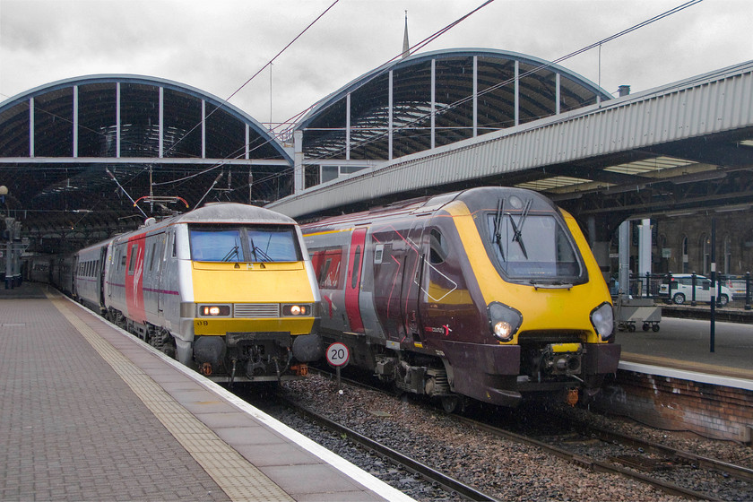 91109, VTEC 13.25 York-Edinburgh Waverley (1F15) & 221128, XC 07.25 Plymouth-Edinburgh Waverley (1S41), Newcastle station 
 In the rain outside the protection of Newcastle's station, Voyager 221128 is leaving ahead of 91109 'Sir Bobby Robson'. The CrossCountry train is the 07.25 Plymouth to Edinburgh whilst the Virgin East Coast working is the 13.25 York to Edinburgh. I suspect that the Class 91 will be hot on the heels of the Voyager as they head north one after the other! 
 Keywords: 91109 13.25 York-Edinburgh Waverley 1F15 221128 07.25 Plymouth-Edinburgh Waverley 1S41 Newcastle station Virgin east Coast Voyager Cross Country trains