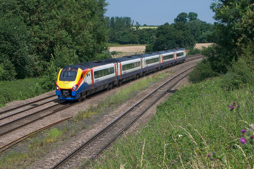 222018, EM 10.16 Corby-London St. Pancras (1P29), Finedon Road industrial estate SP900702 
 A bucolic summer scene just north of Wellingborough sees the 10.16 Corby to St. Pancras Meridian service approach the town. 222018 will be slowing down as it approaches because it is stopping at the station some mile and a half or so south of this location. Soon this scene will change forever with the relaying of the second 'slow' line to the right and the installation of masts and wiring if the electrification of the route ever comes to fruition! 
 Keywords: 222018 10.16 Corby-London St. Pancras 1P29 Finedon Road industrial estate SP900702 East Midlands Trains Meridian