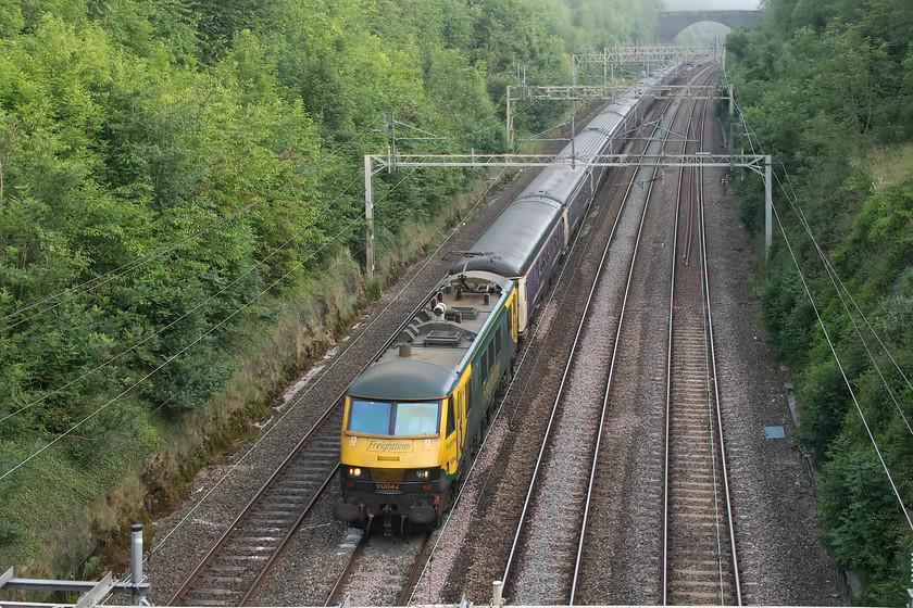 90042, CS 19.50 Fort William, 21.43 Aberdeen, 20.45 Inverness-London Euston (1M16, 3L), Hyde Road bridge 
 The up Highland sleeper passes through Roade taken from Hyde Road bridge. Freightliner's 90042 leads the set of Mk. III stock that started out, as usual from Fort William, Inverness and Aberdeen all coming together in the middle of the night at Edinburgh. In theory, this should be the final up sleeper using the thirty-year-old stock prior to the introduction of the CAF Mk. IV stock. However, with yet more problems appearing within the software systems of the new stock, this has been pushed back again to Septemeber at the earliest. 
 Keywords: 90042 19.50 Fort William 21.43 Aberdeen 20.45 Inverness-London Euston 1M16 Hyde Road bridge