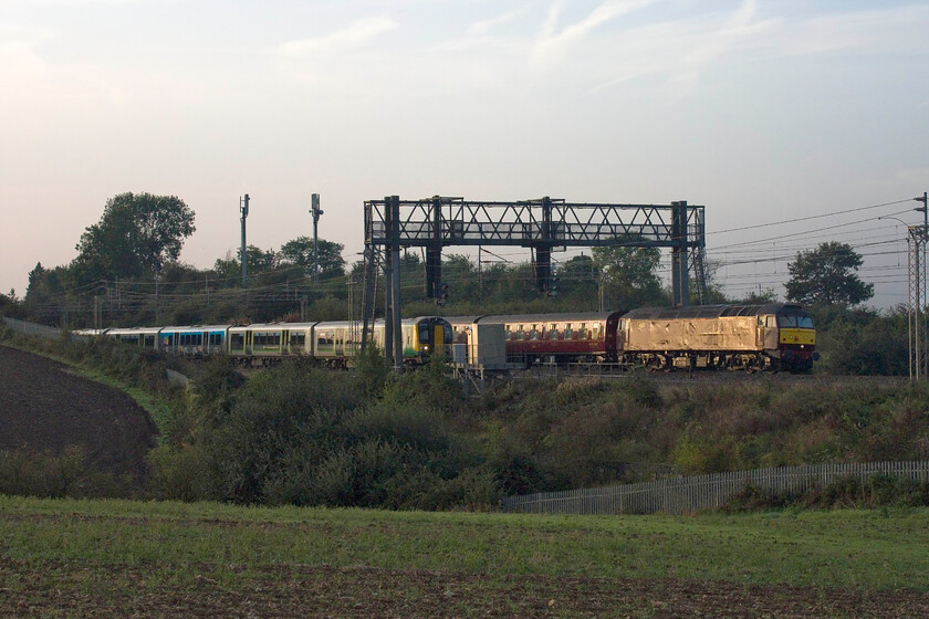 57012, outward leg of The Cumbrian Mountain Express, 06.48 London Euston-Carlisle (1Z86, 24L) & 350235, LN 07.38 Milton Keynes Central-Birmingham New Street (1Y13, RT), between Roade & Ashton 
 So close to being bowled, by two trains! A London Northwestern Desiro had just gone south on the up slow with its tail having just gone out of view as 57012 and 350235 vie for the lead heading north. 57012 is leading the outward leg of The Cumbrian Mountain Express that left London at 06.48 heading for Carlisle and carrying the 1Z86 headcode in a nod to its usual traction, 86259 'Les Ross/Peter Pan'. As the train passed me 350235 just drew level with the locomotive so my positioning at this spot was extremely lucky! 
 Keywords: 57012 The Cumbrian Mountain Express 06.48 London Euston-Carlisle 1Z86 350235 07.38 Milton Keynes Central-Birmingham New Street 1Y13 between Roade & Ashton WCR West Coast Railway