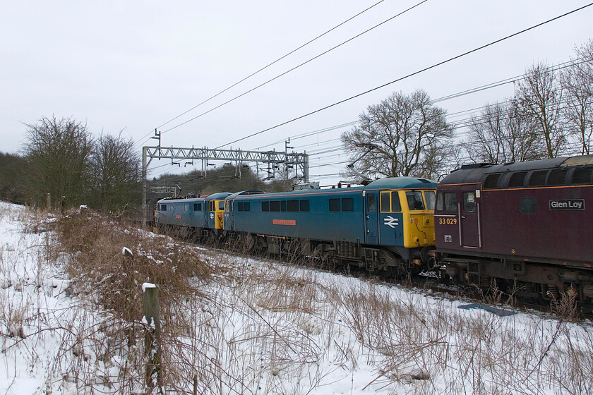 33029, 86101 & 87002, Carlisle-Southall LEs, Roade 
 A bit of a going-away 'grab shot' shows 33029 'Glen Loy', 86101 'Sir William A Stanier FRS' and 87002 'Royal Sovereign' heading south past Roade with 47245 leading the ensemble just disappearing out of sight at the front. The unusual group of locomotives were heading to Willesden from Carlisle for some sort of exam. They would return later in the day. for the electrics to continue their winter stint at Preston stabled and ready for ice-breaking duties. It is unusual to see West Coast send out their Class 33 particularly this far south from their depot at Carnforth. 
 Keywords: Royal Sovereign Glen Loy 33029, 87101 & 86002, Carlisle-Southall LEs, Roade Sir William A Stanier FRS