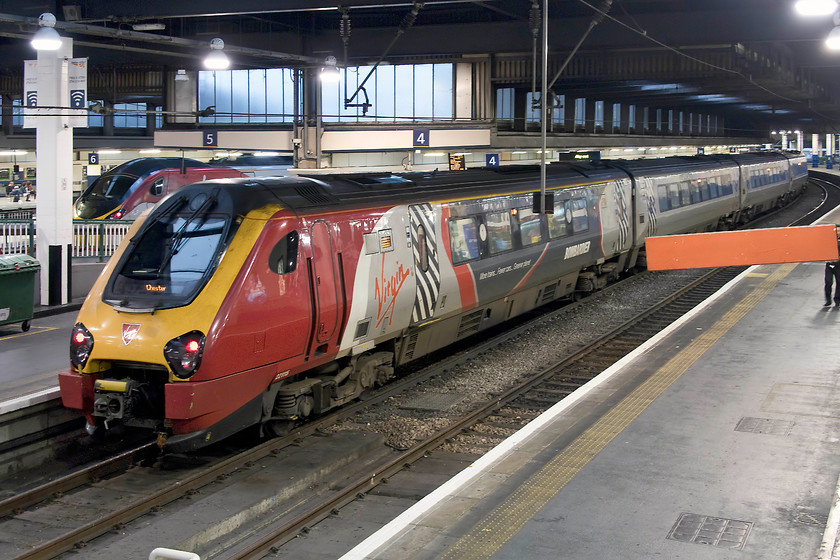 221115 VT 19.10 London Euston-Holyhead (1D93, RT), London Euston station 
 Network Rail, who operate Euston, and Virgin, who operate these trains, have really not got to grips with the pollution issues created by these dreadful and inadequate Voyagers. They absolutely stink out Euston with their unpleasant exhaust permeating its way right up into the concourse. The same problem exists at the 'new' New Street station in Birmingham right up to the upper eating area. I really hope that when Euston is redeveloped that this matter is addressed by either getting rid of the Voyagers or eliminating the problem in other ways. 221115 waits to leave platform four with the 19.10 to Holyhead. 
 Keywords: 221115 1D93 London Euston station