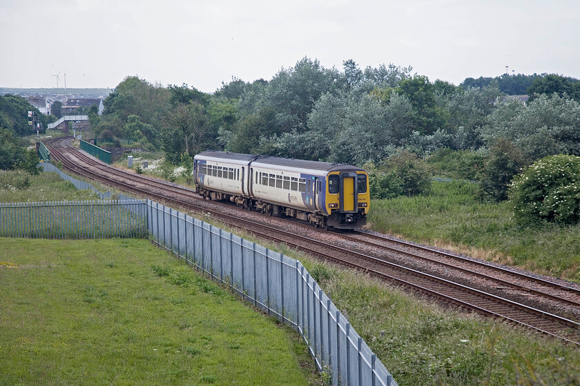 156486, NT 09.28 Barrow-in-Furness-Carlisle (2C45, 6L), Derwent Junction 
 During my survey of the Cumbrian coast line in 1985, I stood at a very similar spot to this in order to photograph Derwent Junction signal box that was located about level with the train on the far side. It controlled a number of lines and sidings that led down to the docks through where the trees are now growing to the right. 156486 has just left Workington station just beyond the footbridge working the 09.28 Barrow-in-Furness to Carlisle service. Incidentally, when I get around to scanning and uploading my 1985 images I will provide a link here; but don't hold your breath! 
 Keywords: 156486 09.28 Barrow-in-Furness-Carlisle 2C45 Derwent Junction Northern