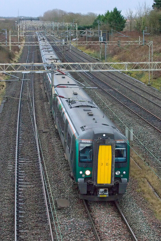 350123 & 350409, LN 12.56 London Euston-Northampton (1Y25, 9L), Victoria bridge 
 250123 and 350409 head north past Victoria bridge near the village of Roade working the 12.56 Euston to Northampton 1Y25 service. I suspect that the train would be relatively quiet, very different to its returning up working that would be taking New Year revellers to London. 
 Keywords: 350123 350409 12.56 London Euston-Northampton 1Y25 Victoria bridge London Northwestern Desiro