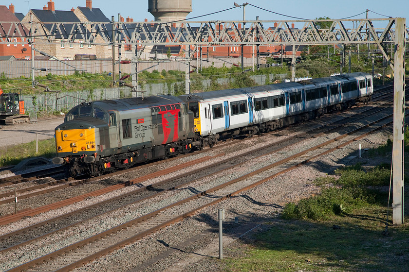 37884 & 317348, 16.12 Ilford EMUD-Kilmarnock (5Q08, 39E), site of Roade station 
 A diesel locomotive dating from 1963 tows a unit dating from 1982 making a combined age of 95 years old! 37885 'Cepheus' tows Greater Anglia 317348 'Richard A Jenner' past the site of Roade station. As the 5Q08 16.12 Ilford depot to Kilmarnock, the train will travel overnight to the Wabtec facility with a lengthy stopover at Carlisle in the 'wee small hours' eventually arriving at about 09.00. I am not absolutely sure as to why these units go to Scotland for a week as they are scheduled for withdrawal. The following day, 37884 brought back another unit, see...... https://www.ontheupfast.com/p/21936chg/29027254804/x0008-37884-317884-0011-0038-kilmarnock 
 Keywords: 37884 317348 16.12 Ilford EMUD-Kilmarnock 5Q08 site of Roade station ROG Rail Operations Group Greater Anglia GA Europheonix Richard A Jenner Cepheus