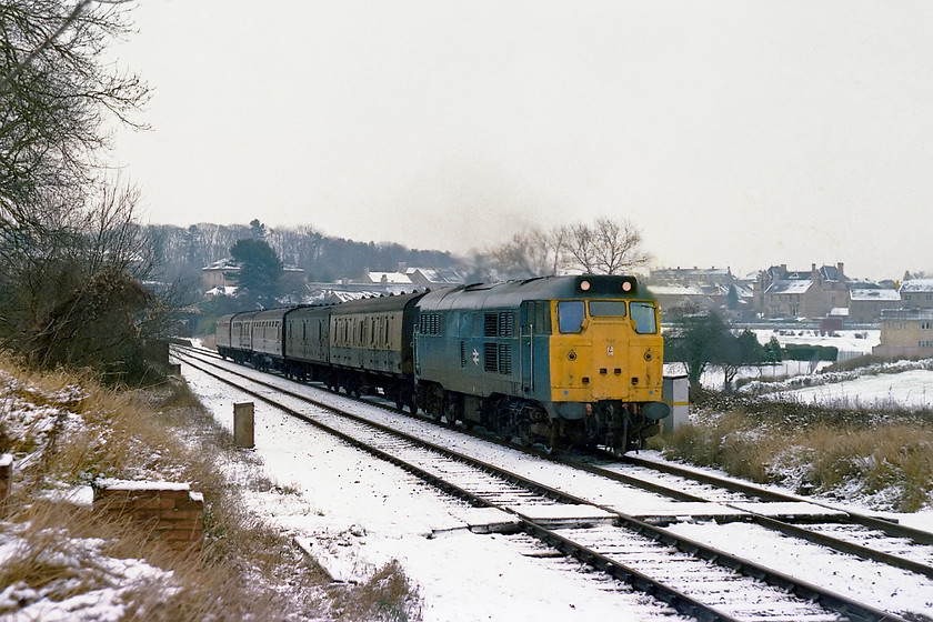 31213, 09.15 Weymouth-Bristol Temple Meads, Bradford-on-Avon number 1 foot crossing 
 With last night's snowfall in evidence, 31213 roars away from Bradford-on-Avon station with the 09.15 Weymouth to Bristol Temple Meads. It has just crossed the River Avon that it will follow all the way to its final destination crossing it a number of times on the way. The charming town of Bradford-on-Avon is in the background where I grew up. Indeed, the snow-covered roof just visible through the shrubs on the far left of the image is the house that I spent the first five years of my life in. In its later life, this Class 31 was renumbered 31465 and fitted with ETH and then, even later to emerge in a bright yellow paint scheme as one of Network Rail's dedicated fleet, see..... https://www.ontheupfast.com/p/21936chg/30014133186/x31465-15-30-derby-euston-down-carr 
 Keywords: 31213 09.15 Weymouth-Bristol Temple Meads Bradford-on-Avon