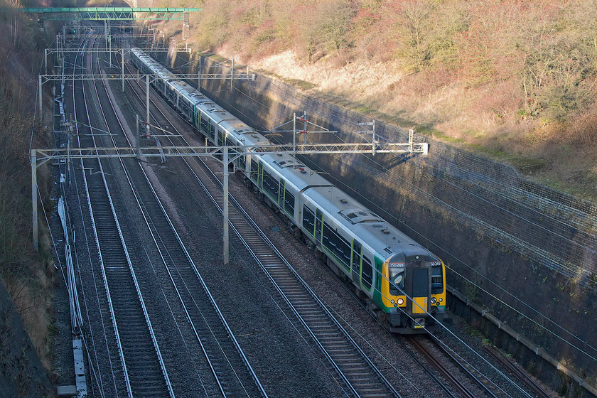 350249, LN 11.54 Birmingham New Street-London Euston (2Y38, RT), Roade Cutting 
 As London Northwestern were operating a 'reduced' timetable on this Christmas Eve, their services were strengthened with all the ones I observed being formed of three sets of class 350s. Here, 350249 leads two other units forming the 11.54 Birmingham New Street to London Euston through Roade Cutting that is, as usual at this time of year, in deep shade. 
 Keywords: 350249 11.54 Birmingham New Street-London Euston 2Y38 Roade Cutting