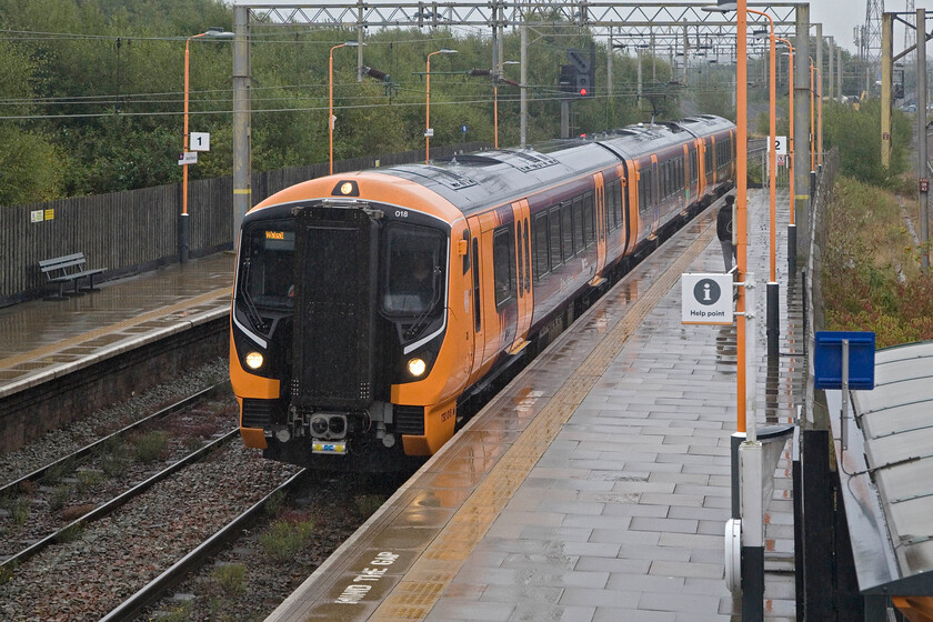 730018, LN 08.48 Wolverhampton-Walsall (2A11, 1L), Bescot Stadium station 
 In absolutely pouring rain, 730018 'Hurst Street' arrives at Bescot Stadium station working the 08.48 Wolverhampton to Walsall West Midlands Trains service. At present, this is the only named Class 730 receiving its vinyl 'plates' as part of the Birmingham Pride events in May 2024. 
 Keywords: 730018 08.48 Wolverhampton-Walsall 2A11 Bescot Stadium station Hurst Street