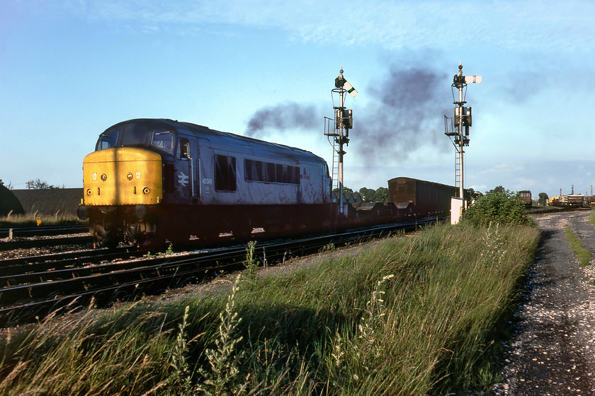 45048, down freight, Fairwater Yard 
 How I managed to get this far into Fairwater Yard and remain unchallenged is quite a surprise! However, it has provided me with an opportunity to take a photograph of the down yard starter signals complete with their route describers both of which are controlled by Silk Mill Junction signal box. 45048 gets away from the yard in typical smokey style leading a down freight that looks as though it could have been of MoD origin with the two low loaders marshalled behind the loco and the 1920s vintage corrugated end wagons behind them. If anybody with local knowledge could advise as to what this working could have been please do get in contact with me. 
 Keywords: 45048 down freight Fairwater Yard