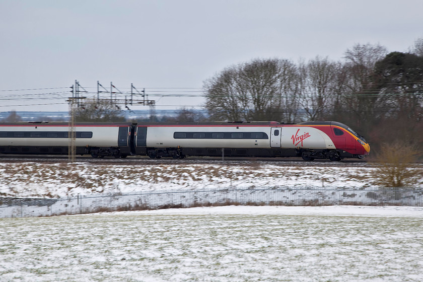 390154, VT 11.16 Manchester-London Euston (1A17, 4L), between Roade & Ashton 
 390154 'Mission Accomplished' heads south forming the 11.16 Manchester Piccadilly to London Euston. The remains of some overnight snow adds to the rather otherwise drab scenery. The picture is taken a short walk from where I live near Roade in Northamptonshire. 
 Keywords: 3901541A17 Roade & Ashton