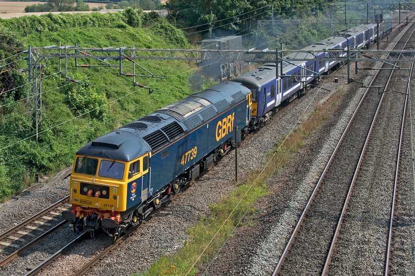 47739, 360112 & 47727, 11.22 Ilford EMUD-Northampton EMD (5Q60, 41E), Victoria bridge 
 47739 leads the 11.22 Ilford depot to Northampton EMD past Victoria bridge in deepest Northamptonshire. The 5Q60 working was conveying Desiro 360112 from its London base to the Siemens depot at Kingsheath in order for modifications to be carried out. These modifications are in order for it to operate on the recently electrified but yet to be live MML where these sets will run between St. Pancras and Corby. Caledonian Sleeper liveried 47727 'Edinburgh Castle/Caisteal Dhun Eideann' is at the rear of the train. 
 Keywords: 47739 360112 47727 11.22 Ilford EMUD-Northampton EMD 5Q60 Victoria bridge GBRF Edinburgh Castle Caisteal Dhun Eideann