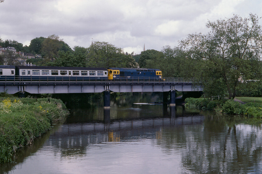 Class 33, unidentified Cardiff-Portsmouth Harbour working, Avon bridge Bradford-on-Avon 
 An unidentified Class 33 enters Bradford-on-Avon station that is just to the right of the tree leading a Bristol to Portsmouth Harbour service. It is crossing the River Avon with the town's two church spires in the background with the nearest being that of Holly Trinity and the one on the top of the hill in the distance being Christchurch. 
 Keywords: Class 33 Cardiff-Portsmouth Harbour working Avon bridge Bradford-on-Avon Crompton