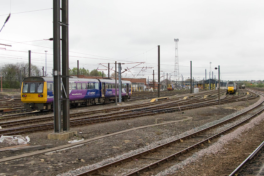 142023, class 08 & class 43, stabled, Neville Hill depot 
 Passing Neville Hill depot very little is seen in and around the facility. To the left, a Norther Trains' Pacer 142023 is seen stabled. In the mid-distance, a class 08 is sat idle between duties whilst and unidentified CrossCountry hst is being serviced with its nose cone in the raised position. 
 Keywords: 142023 class 08 class 43 Neville Hill depot HST CroosCountry Trains Pacer