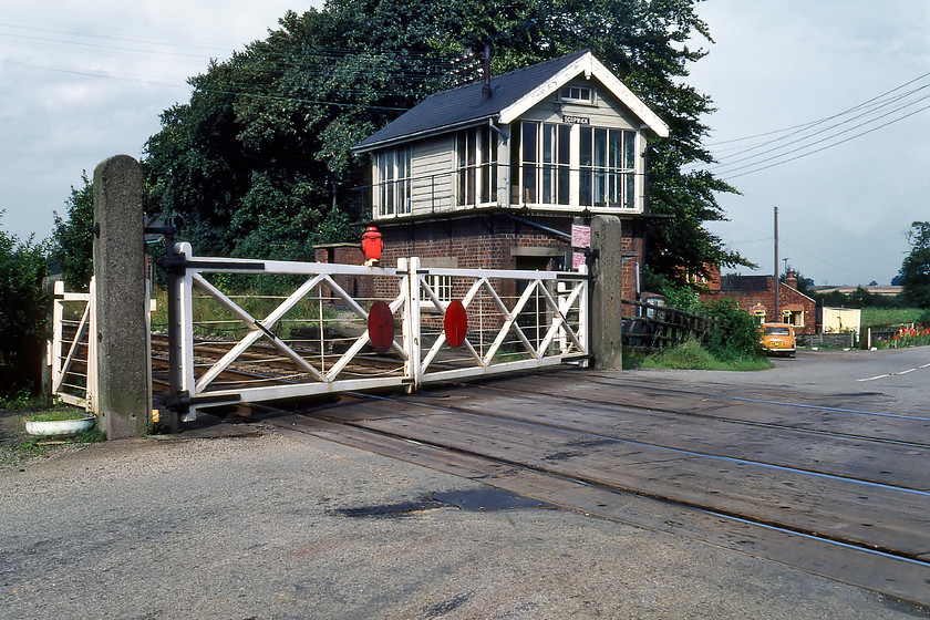 Scopwick signal box (LNER, 1937) 
 Wreaking of railways from another era is this delightful scene at Scopwick where the B1191 road crosses the Sleaford to Lincoln line. The signal box is a superb example of an LNER box dating from 1937 seen here with its associated manually operated gates with a red oil lamp. It is scenes such as this that typified rural Linconshire's railways, a situation that continued largely unchanged until Network Rail dragged the line into the modern era in 2014. The box has now gone with the gates replaced by standard barriers. Notice our orange Mini parked in the distance with the former station master's house beyond it. Incidentally, the station here was names Scopwick & Timberland and was closed on 07.11.55. 
 Keywords: Scopwick signal box London and North Eastern Railway LNER