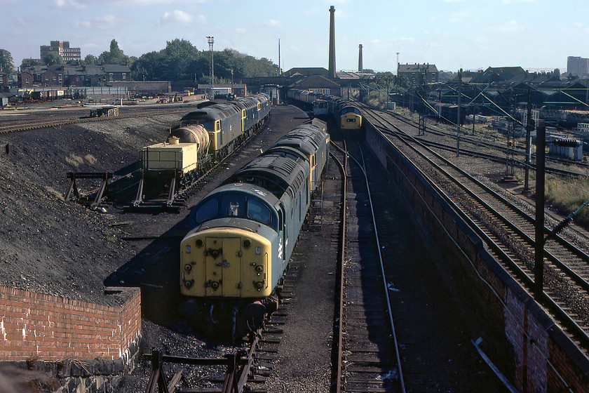 40048, 40063 & others, awaiting attention, Crewe Works 
 Taken from the footbridge that permitted access to the works on the day, that was packed with enthusiasts waiting to get into the works, the reception and scrap lines are seen. Unfortunately, I only have two numbers for all these locomotives, in the foreground, 40048 sits looking very sorry for itself heavily stripped. It was withdrawn in October 1977 as 'surplus to requirements'. I do not understand why, later in June 1980, it was towed to Doncaster for final cutting rather than being disposed of here at Crewe. Despite appearances, 40063 was not on the scrap line up against the wall but was a Crewe for attention. It lived on until withdrawal at Bescot in 1984 with eventual cutting at Vic Berry's in 1988. 
 Keywords: 40048 40063 Crewe Works