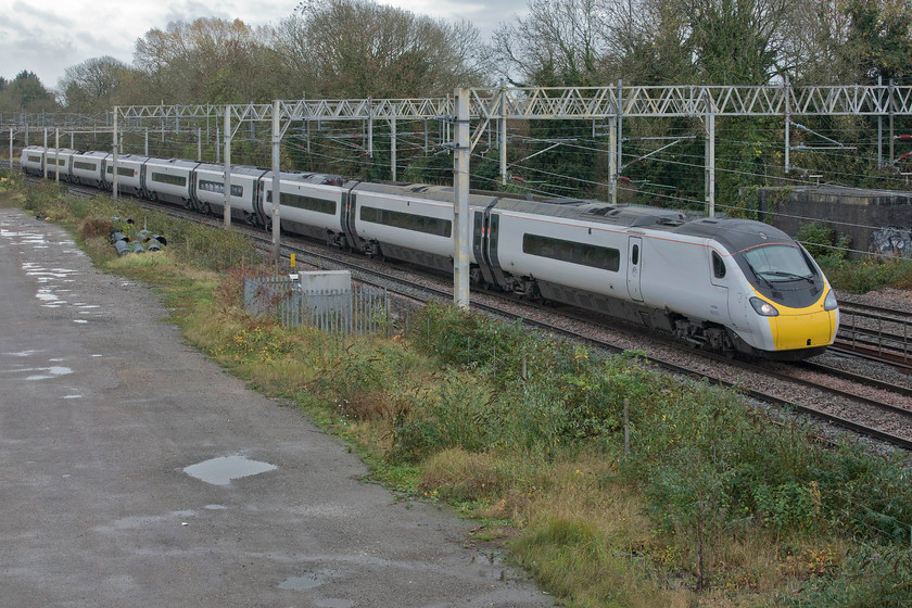 390010, VT 13.10 London Euston-Glasgow Central (1S69, 38L), site of Roade station 
 Making very sedate progress along the down slow line and stacked up behind a procession of other trains, 390010 'Cumbrian Spirit' passes Roade working the 1S69 13.10 Euston to Glasgow Central. After a morning of pretty relentless rain and strong wind, the weather has improved with some blue sky putting in an appearance behind me, not that you would know from this photograph! This particular Pendolino was the first one to appear in Virgin's very smart flowing silk revised livery back in the autumn of 2017. Now it is one of the diminishing numbers of units still running around debranded almost a year after Avanti West Coast took over the franchise in December 2019. 
 Keywords: 390010 13.10 London Euston-Glasgow Central 1S69 site of Roade station Cumbrian Spirit