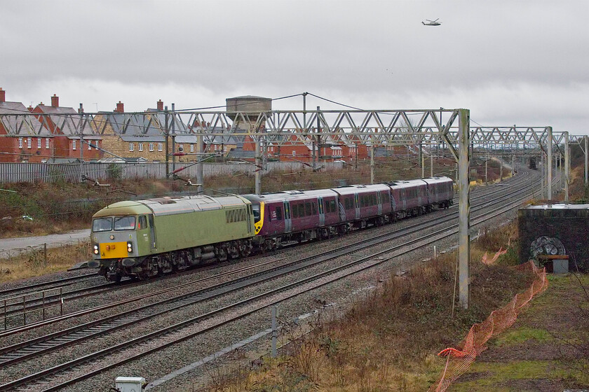 69010 & 360119, 12.57 Kettering Stabling Sidings-Northampton EMD (5Z61, 1E), site of Roade station 
 I was not quite prepared for what was leading the 12.57 Kettering Stabling Sidings to Northampton (Siemens) EMD stock move! I am more used to seeing a Class 47 haul this regular working so when 69010 (formally 56060) appeared I was pleasantly surprised. 360119 was being taken to Northampton for an examination before returning back to its more usual MML haunts in a few days time. Notice the Sikorsky S-76C-2, call sign G-ROON, heading southwestwards above the scene. It had taken off from Pannal Golf Club (near Harrogate) earlier in the morning taking a somewhat circuitous route heading to an unidentified location. 
 Keywords: 69010 360119 12.57 Kettering Stabling Sidings-Northampton EMD 5Z61 site of Roade station EMR Desiro