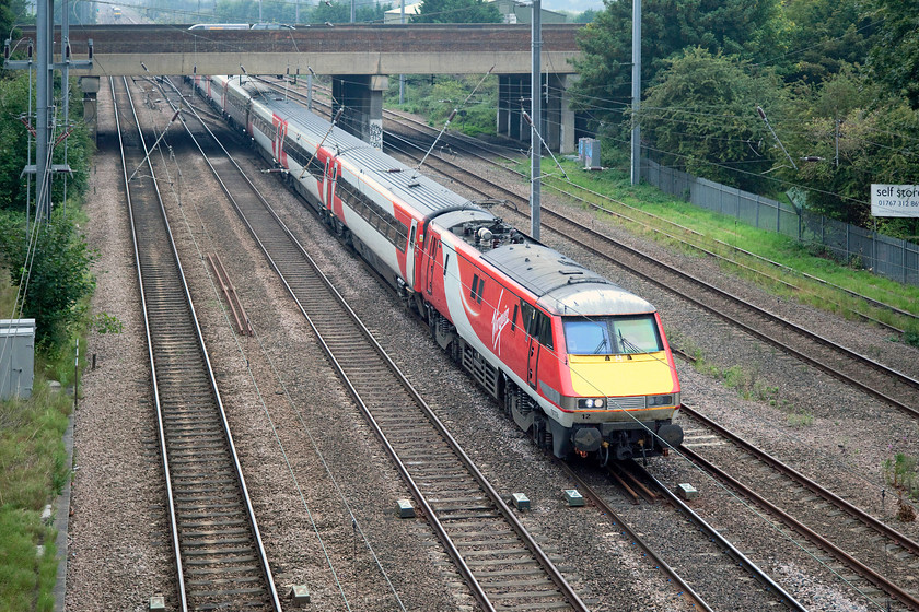 91112, GR 09.30 London Kings Cross-Edinburgh Waverley (1S10, RT), Biggleswade Grasmere Road footbridge 
 91112 leads the 09.30 Kings's Cross to Edinburgh under the A1 dual carriageway to the south of Biggleswade. The are six tracks in view here with the two to the far side being associated with some sidings to the south of Biggleswade station. 
 Keywords: 91112 1S10 Biggleswade Grasmere Road footbridge