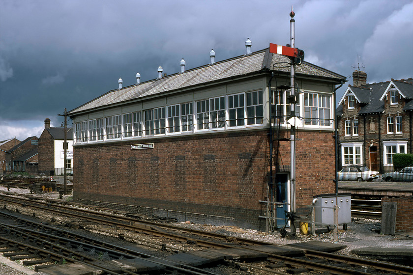 Taunton West signal box (GW, 1931) 
 The grand Taunton West signal box is seen from the platform end of the station with the down main home signal in front. The post holding the home also had a distant arm, hence its odd positioning slightly lower down the post than it ought to be. The Great Western Type 11 box was opened in 1931 when the station area was completely re-modelled in the constant drive to improve speed and timings. Any picture taken from this spot reveals cars parked on the appropriately named Railway Street in the background. On this particular Saturday, there was a white Hillman Hunter with a vinyl roof and a Mk.III 'Coke Bottle' Cortina. 
 Keywords: Taunton West signal box