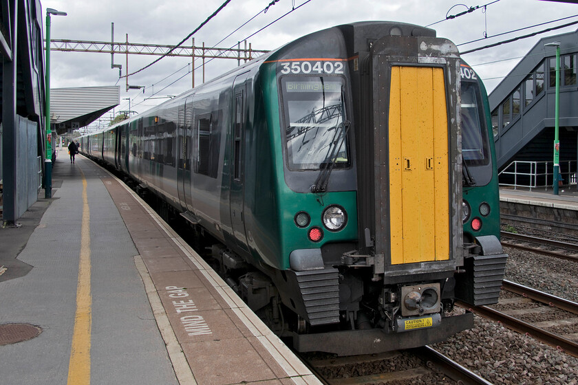 350402, LN 12.49 London Euston-Birmingham New Street (1W13, RT), Northampton station 
 Having arrived back in Northampton I turned my camera around to capture the rear of our train as it rests for some ten minutes prior to departing for Birmingham New Street. My wife and I travelled on the 12.49 from Euston finding it extremely busy, to begin with at least, however many passengers alighted at Watford Junction where we stopped on the down fast platform. The train manager also made a clear announcement just prior to this stop that Oyster validity finished at Watford. Notice that we had the luxury of travelling in one of the small subset of ex TPE 350/4s. These offer a much more pleasant ambience and roomy travelling experience than the rather tired and battle worn 350/1,2 and 3s. 
 Keywords: 350402 12.49 London Euston-Birmingham New Street 1W13 Northampton station London Northwestern Desiro