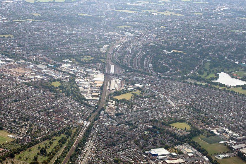 Wimbledon depot, from flight SU2582 
 Having completed one one hundred and eighty degrees turn Aeroflot flight SU2582 then completed another sharp turn over south London to line up for its final descent into Heathrow. In this view, the large Wimbledon depot is seen in the centre of the image. To the bottom of the image is Earlsfield station with the line to Putney going off to the right past Wimbledon Park lake. Towards the top of the image, Wimbledon station can be clearly seen with a southbound train about to arrive at the station. 
 Keywords: Wimbledon depot from flight SU2582