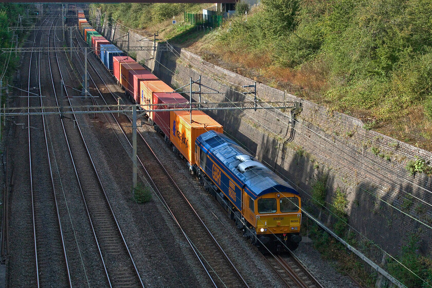 66305, 14.06 Birch Coppice-London Gateway (4L68, RT), Roade cutting 
 66305 has led a varied and interesting history. It was ordered as one of five by Fastline (now owned by Jarvis) back in 2008. Jarvis went into administration in 2010 taking the Fastline name with them. The five Class 66s were subsequently acquired by DRS who painted them into their 'basic' blue livery. In 2022 GBRf then took on the five locomotives (66301-66305) leasing them from Beacon Rail but it has taken some time for them to be re-livereid and, in some cases, named. In its sparkling new paint, 66305 now named 'Embsay & Bolton Abbey Steam Railway', passes Roade leading the 14.06 Birch Coppice to London Gateway afternoon service. The locomotive was named in a ceremony earlier this month at the heritage line, there is a post covering this event on their Facebook page, see... https://www.facebook.com/embsayrailway 
 Keywords: Embsay & Bolton Abbey Steam Railway 66305 14.06 Birch Coppice-London Gateway 4L68 Roade cutting