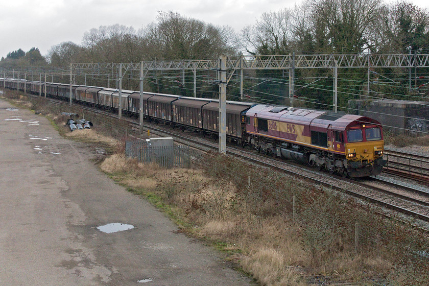 66106, 11.06 Dollands Moor-DIRFT (6C24, 31L), site of Roade station 
 66106 leads the daily bottled water train through Roade passing the site of the village's former station. I had to sprint from the other side of the bridge to take this photograph as I realised just seconds before it came into view that I was about to be bowled by a Pendolino heading south - the roof of which can be seen passing the rear of the 11.06 Dollands Moor to Daventry train. The last time that I photographed this EWS liveried Class 66 was in a different part of the country a couple of years previously, see..... https://www.ontheupfast.com/p/21936chg/26273797404/x66106-10-55-knowsley-freight-terminal 
 Keywords: 66106 11.06 Dollands Moor-DIRFT 6C24 site of Roade station EWS