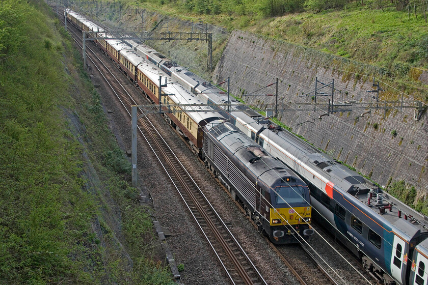 67006 & 67021, 07.50 London Victoria-Liverpool South Parkway (1Z39, 3L) & Class 390, VT 08.47 Birmingham New Street-London Euston (1B29, 3L), Roade cutting 
 As the 08.47 Birmingham New Street to Euston Avanti West Coast service heads south through Roade cutting as something far more interesting heads north! 67006 'Royal Sovereign' leads the 1Z39 07.50 Victoria to Liverpool South Parkway charter with 67021 on the rear. The train is conveying racegoers, no doubt enjoying a champagne breakfast, to Merseyside for the Grand National. In past years the charter would have been able to access the racecourse directly terminating at Aintree station which had a number of excursion sidings for the stabling of stock. With those now long-gone passengers are forced to transfer to Merseyrail services for the final leg of their journeys; not quite the same is it really? With regard to the race itself, last year's winner Corach Rambler failed to finish with the joint favourite I Am Maximus winning at 7/1. My wife and son both were able to collect a healthy payout as they both backed the Willie Mullins-trained winner recovering their losses over the last ten years or so of betting on the National! 
 Keywords: 67006 67021 07.50 London Victoria-Liverpool South Parkway 1Z39 Class 390 08.47 Birmingham New Street-London Euston 1B29 Roade cutting AWC Pendolino Pullman