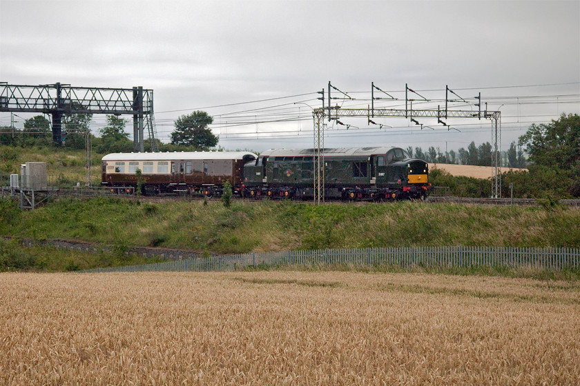 37521, 15.55 Eastleigh Arlington-Crewe HS (5Z37, 33E), between Roade & Ashton 
 In abysmal lighting 37521, masquerading as D6817, passes between Ashton and Roade leading a very smartly repainted Mk.II 17056 in Statesman Rail's cream and brown livery. It was returning to Crewe from Eastleigh as 5Z37 after towing some HST power cars the other way earlier in the day, see..... https://www.ontheupfast.com/p/21936chg/29301192804/x37521-43046-43055-07-14-crewe-hs . On a dull and drizzly summer's evening the reproduction British Railways' green livery carried by the Class 37 blends very nicely with the background!

An audio recording of this event can be enjoyed at..... https://youtu.be/Y1Ncsh8Fy10 
 Keywords: 37521 15.55 Eastleigh Arlington-Crewe HS 5Z37 between Roade & Ashton D6817 Mk. II 17056