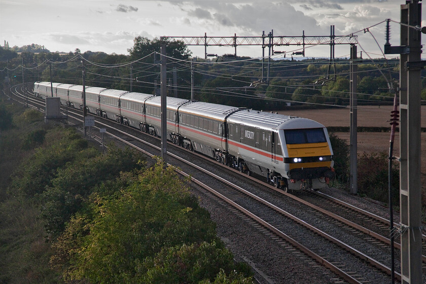 82139 & 90002, 16.02 Manchester Piccadilly-London Euston (1Z96, 11L), Blisworth 
 I believe that the esteemed railway photographer and writer O.S. Nock once said that the one rule of railway photography was always to have the camera facing away from the sun. Well, I like breaking the rules and here is a good example and one that has just about worked! Taken against the strong setting sun that was partially obscured by cloud at Blisworth DVT 82139 catches the light as it leads the 16.02 Manchester to Euston LSL relief service operating in connection with the death of the Queen. On the rear of the fine set of Intercity Swallow liveried stock is 90002 ' Wolf of Badenoch' providing the power. It's a shame that in recording the extremely contrasty image the camera did not manage to record any colour in the sky. I could have resorted to some Photoshop jiggery-pokery but resisted the urge to keep it 'as taken.' 
 Keywords: 82139 90002 16.02 Manchester Piccadilly-London Euston 1Z96 Blisworth Wolf of Badenoch DVT Intercity Swallow