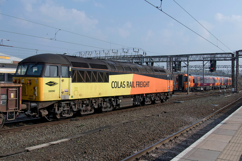 56090, 13.33 Crewe Basford Hall-Longport Colas (6K39, 14E) & 196002, 13.34 Birmingham New Street-Crewe (5Q83, 4E), Crewe station 
 Old meets new at Crewe station. Having just celebrated its forty-first birthday two weeks previously veteran 56090 faces a brand new train arriving at one of the south-facing bay platforms. Whilst the Grid is in service and about to leave with the 6K39 13.33 Basford Hall to Longport infrastructure train made up of a set of loaded MCA bogie open wagons 196002 was arriving with a test train running as 5Q83, the 13.34 Birmingham New Street to Crewe. These smart looking Spanish constructed (by CAF) Class 196s will soon be in operation on the West Midlands Trains network as a replacement for their ageing Class 170 units. 
 Keywords: 56090 13.33 Crewe Basford Hall-Longport Colas 6K39 196002 13.34 Birmingham New Street-Crewe 5Q83 Crewe station Colas Rail Freight West Midlands Trains