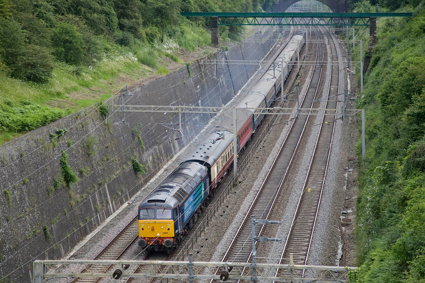 47841, 13.44 London Euston-Crewe HS ECS (5Z28), Roade cutting 
 Having undertaken its charter work over the previous three days the stock from the 2014 Three Peaks Challenge charity event returns north back towards where it is kept at Crewe. The rag-bag collection of stock is being led through Roade cutting by a rather smokey DRS 47841 running as 5Z28 that left Euston at 13.44. 
 Keywords: 47841 13.44 London Euston-Crewe HS ECS 5Z28 Roade cutting