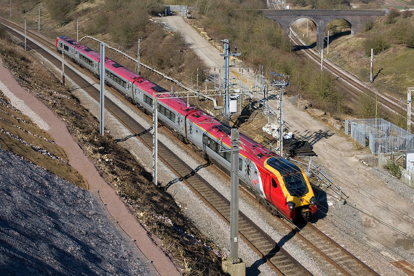 Class 221, VT 11.28 Chester-London Euston (1A18), Blisworth Road bridge 
 A Virgin West Coast Voyager approaches Roade cutting from the north working the 11.28 Chester to Euston service. The line curving away to the right is the Northampton loop. In days past when a more sensible and measured approach was taken spotters used to be able to access the apex of the two lines and collect numbers all day long. All of the area seen in this view is no completely off-limits. 
 Keywords: Class 221 11.28 Chester-London Euston 1A18 Blisworth Road bridge Virgin West Coast Voyager