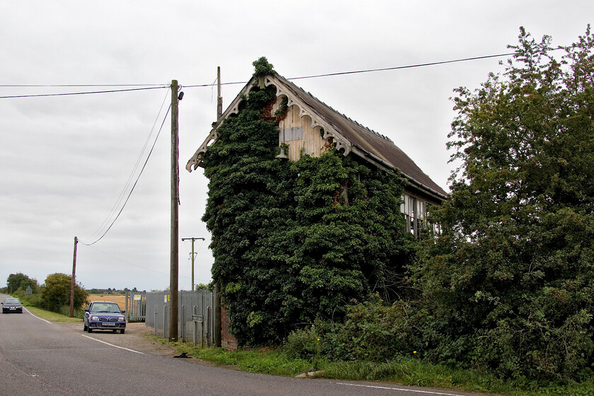 Former Postland signal box (GN, 1882) 
 When I last photographed Postland signal box on 16.08.81 it was in superb condition looking like it had just been in receipt of a paint. Just over forty years later it is still standing (just!) but in need of a little more than a repaint now! The box last signalled a train on the former GN & GE Joint line in 1982 and really needs somebody to take it on now before it is too late but what a project! Notice Andy's trusty Nissan Micra, our steed for many trips, parked near the entrance gate of Fenland Tractors.

NB just a fortnight later the Micra failed its MoT in spectacular fashion needing a huge amount of welding to keep it on the road. Andy took the plunge and had the work done! 
 Keywords: Former Postland signal box GN