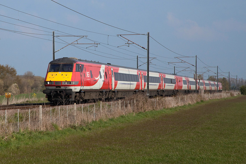 82216 & 91112, GR 06.57 Edinburgh-London King`s Cross (1E04 2L), Cromwell Lane crossing SK792616 
 DVT 82216 leads the 06.57 Edinburgh to King's Cross with 91112 at the rear. The train is seen about to pass over Cromwell Lane level crossing a short distance north of Newark. In this final incarnation before removal from the ECML these trains look very smart in their former Virgin East Coast livery with the LNER branding. Notice the milepost to the extreme left of the picture indicating that this service has one hundred and twenty five miles to go in order to reach its destination. 
 Keywords: 82216 91112 06.57 Edinburgh-London King`s Cross 1E04 Cromwell Lane crossing SK792616