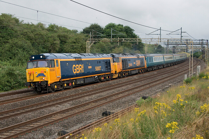 50007 & 50049, outward leg of 'The Thanet Thunderer', 06.05 East Midlands Parkway-Margate (1Z32, 2L), Old Linslade 
 Spot the error......with a Class 50 hauled charter including the word 'Thunderer' one would expect to see 50008 hauling the train and this was the plan! However, a short while after leaving its Severn Valley base the previous day to reach Burton-on-Trent 50008 failed its 'fitness to run' exam at Bescot so was hastily returned whence it came from and 50049 was substituted. The Branch Line Society charter, with an ambitious route, was able to run and did so to time throughout the day with the locomotives appearing to behave themselves faultlessly. Making a fine site 50007 'Hercules' leads 50049 'Defiance' on the outward leg of the charter past Old Linslade that had left East Midlands Parkway at 06.05 heading for Margate. It was good that the signallers had the confidence that the combined five thousand four hundred horsepower could keep the train going at a sustained one hundred miles per hour as they put it out on the fast after it left Bletchley despite being sandwiched between a Pendolino and a Voyager! 
 Keywords: 50007 50049 'The Thanet Thunderer' 06.05 East Midlands Parkway-Margate 1Z32 Old Linslade Hercules Defiance Hoover GBRf GB Railfreight