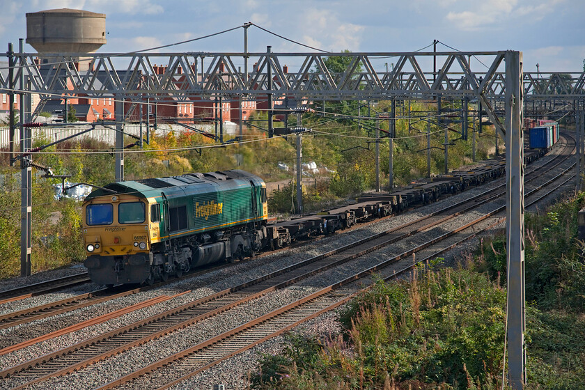 66567, 09.14 Southampton MCT-Garston (4M58, 6L), site of Roade station 
 Just about managing to dodge the lengthening September afternoon shadows 66567 is seen passing the site of Roade's former station leading then 09.14 Southampton to Garston Freightliner service. I am always a little disappointed when a Freightliner or intermodal train has empty flats behind the locomotive as is seen here making it similar to a light engine may look. 
 Keywords: 66567 09.14 Southampton MCT-Garston 4M58 site of Roade