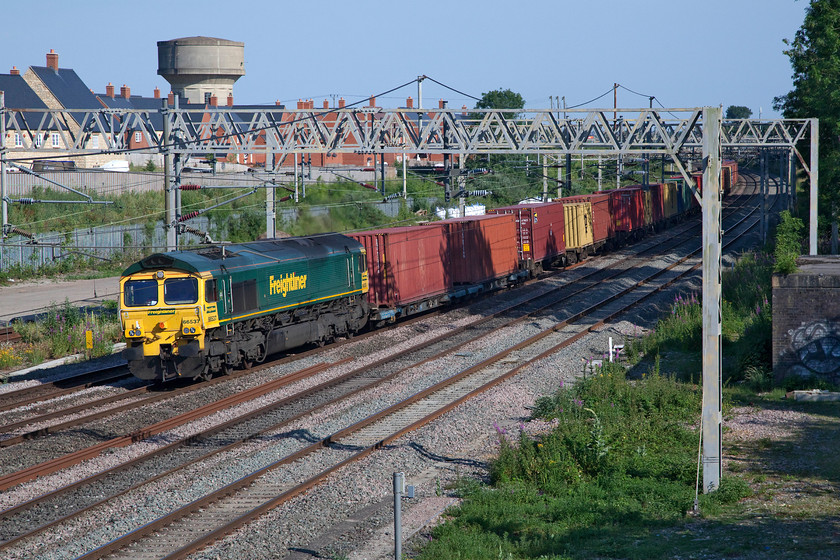 66537, 12.57 London Gateway-Garston (4M56, 40E), site of Roade station 
 On a glorious late summer afternoon at Roade 66537 leads the 4M56 12.57 London Gateway to Garston Freightliner. This is a superb location for an afternoon of photography when the sun is out being on a footbridge that is busy with locals going about their business but always wondering what a strange person is doing sitting on a stool with a camera around their neck. If I had a pound for every time that I have been asked 'Is there anything special coming?' I'd be a rich man! 
 Keywords: 66537 12.57 London Gateway-Garston 4M56 site of Roade station Freightliner