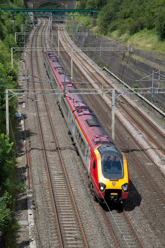 Class 221, 08.51 Edinburgh-London Euston (9M52), Roade Cutting 
 In full summer sunshine, a Virgin Trains class 221 in the final phase of its journey from Scotland as the 08.51 Edinburgh to London Euston. Again, I have to question the economics of running a diesel all the way under the fully energised live wires on a journey such as this. 
 Keywords: Class 221 08.51 Edinburgh-London Euston 9M52 Roade Cutting