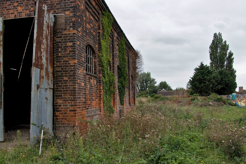 Former goods shed & trackbed, Cowbit 
 Looking south at Cowbit sees the former goods shed to the left with the gable end of the signal box in the middle distance. The trackbed of the former GN & GE Joint line ran to the centre right where the building work is taking place. Travelling south on the line ended up at March whilst behind me it Spalding was only a few miles away. If the line had not been closed in 1982 by BR just consider what a significant route it would now be for freight to and from the East Coast ports as well as passenger diversions. 
 Keywords: Former goods shed & trackbed Cowbit