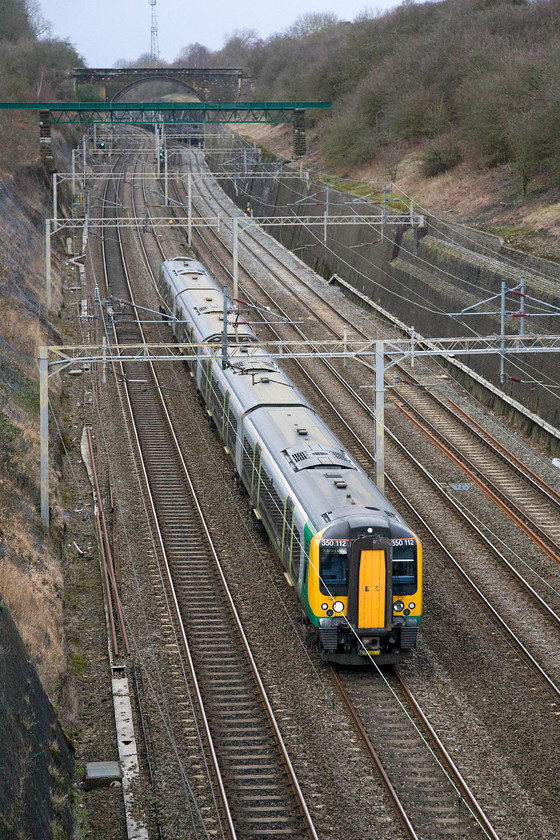 350112, LM 13.02 Crewe-London Euston (1U32), Roade cutting 
 Having taken the 'fast' Weedon route avoiding Northampton 350112 heads south through Roade cutting with the 13.02 Crewe to Euston. 
 Keywords: 350112 LM 13.02 Crewe-London Euston 1U32 Roade cutting London Midland Desiro