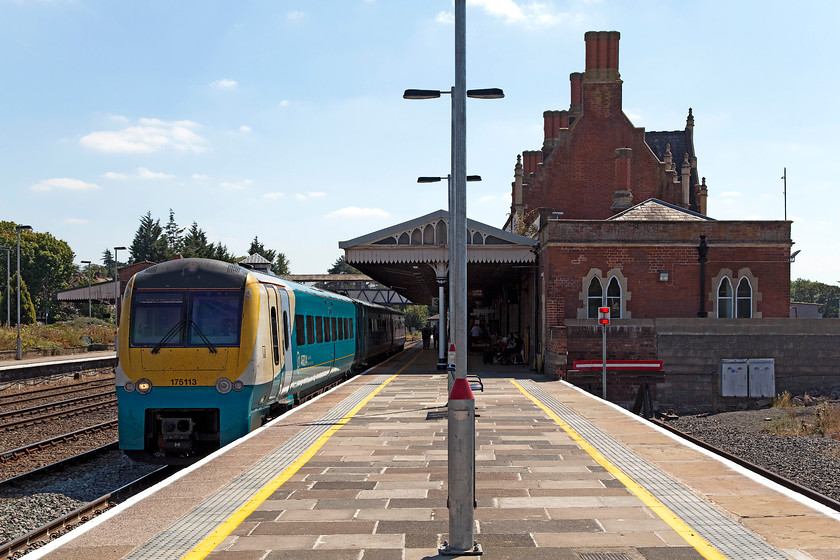 175113, AW 11.21 Cardiff Central-Holyhead (1W93), Hereford station 
 Taken a bit into the sun but I wanted a picture that showed off Hereford's superb Victorian Gothic station building, designed by R.E. Johnson, that opened in 1853 as a joint station called Hereford Barrs Court. 175113 leaves the station working the 11.21 Cardiff to Holyhead service, a journey that effectively goes the whole length of Wales from south to north. 
 Keywords: 175113 11.21 Cardiff Central-Holyhead 1W93 Hereford station