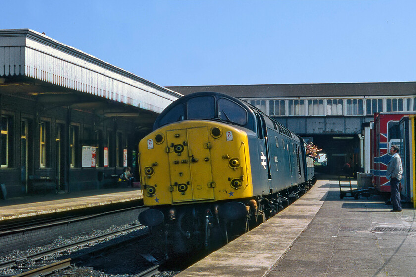 40018, 12.00 Manchester Victoria-Holyhead (1D38), Colwyn Bay station 
 There was a number of Class 40 hauled services along the North Wales coast, particularly on Sundays however, in these pre-internet days it was potluck as to whether one was seen. Graham and I were lucky whilst calling in at Colwyn Bay station with the down line being pegged and the grand sight of the 1D38 12.00 Manchester Victoria to Holyhead appearing in the distance. 40018 (formally named 'Carmania') had just six more weeks in service being withdrawn on 15.09.81 at Crewe. Notice the huge group of bashers flailing from the droplights of the leading Mk. 1 coach watched by a bemused 'normal' on the platform! Also, notice the rather extreme camber of the track through the western end of the station taken in some style by the 40 at line speed; what a sight! 
 Keywords: 40018 12.00 Manchester Victoria-Holyhead 1D38 Colwyn Bay station Carmania