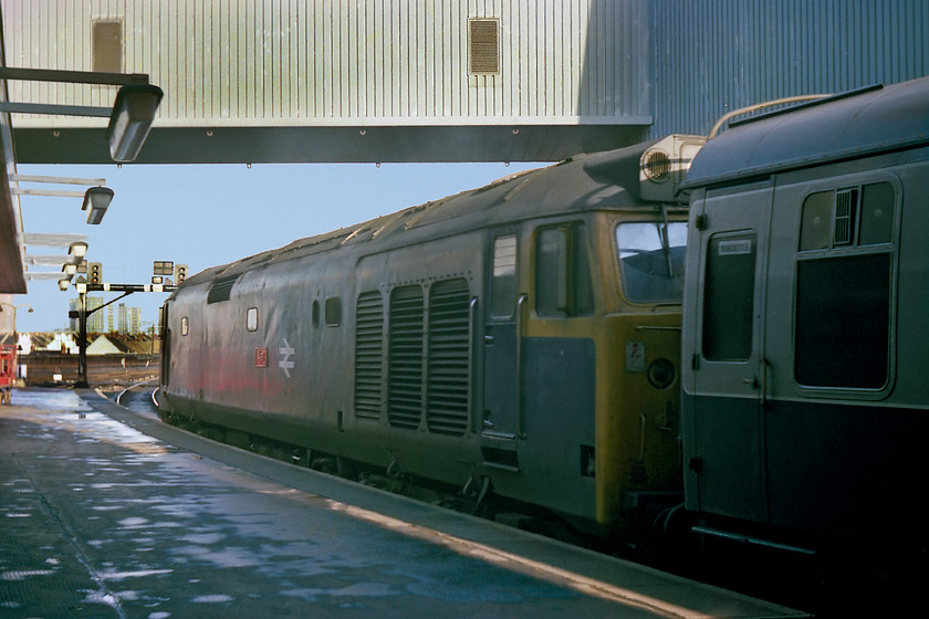 50046, 11.10 Plymouth-Manchester Piccadilly (1M22), Bristol Temple Meads station 
 50046 'Ajax' waits at Bristol Temple Meads leading the 1M22 11.10 Plymouth to Manchester Piccadilly. 50046 was named approximately eight weeks prior to this image being taken, indeed it was the penultimate member of the class to be named. However, notice that the BR double arrow emblem has yet to be moved to the cab end as was the practice when the plates were applied. It is likely that the 50 will have hauled the train as far as Gloucester where another diesel may have taken over or to Birmingham New Street where an AC electric will have taken it on. The loco. is standing under the Royal Mail's covered conveyor that carried mail bags over to the large sorting office adjacent to the station. Unfortunately, after closure, this building derelict and vandalised blighted Temple Meads and this part of Bristol for over twenty years. Thankfully, it has now been demolished to make way for a new university campus building. Finally, notice the gummed destination label stuck to the droplight of the leading Mk.1. Did many of you, like me, collect these as mementoes? Amazingly, some forty years later, they are still used but in a slightly different form on ECML trains! 
 Keywords: 50046 11.10 Plymouth-Manchester Piccadilly 1M22 Bristol Temple Meads station